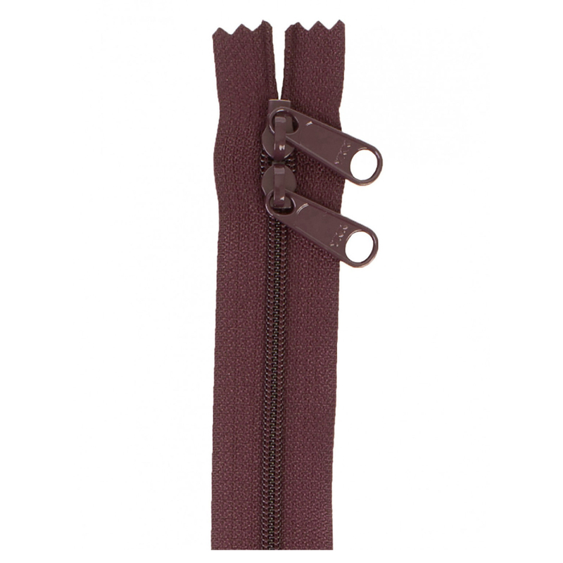 Photo of a burgundy zipper with two pull tabs isolated on a white background