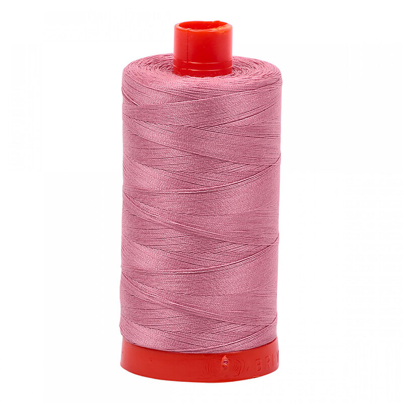 A spool of Aurifil 2445 - Victorian Rose thread on a white background, a dusty rose pink tone
