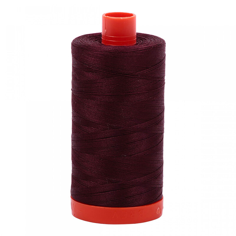 A spool of Aurifil 2468 - Dark Wine thread on a white background, with tones of deep merlot and midnight purple