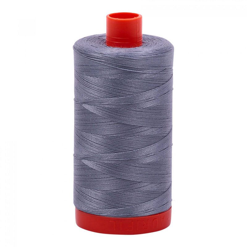 A spool of the Aurifil 6734 - Swallow thread on a white background, tones of haze, smoke, fog, steel, and pale periwinkle