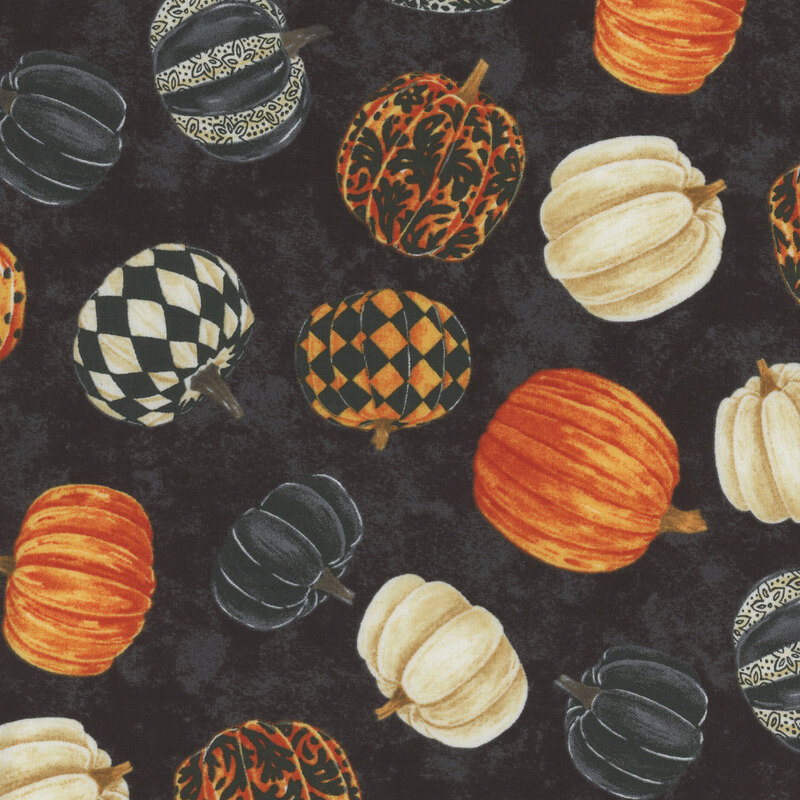 black mottled fabric featuring scattered orange, white, and black pumpkins, with some of the pumpkins decorated with various patterns