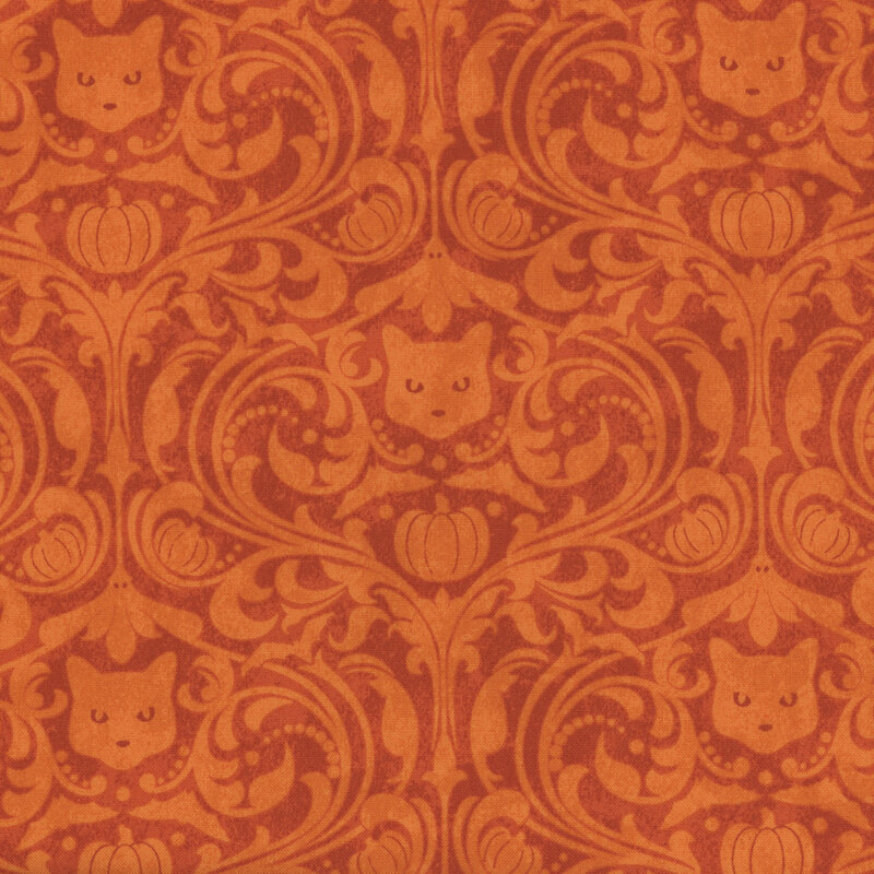 orange fabric featuring a lighter orange damask pattern, which includes cat heads, pumpkins, and ghosts