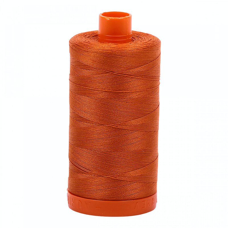 A spool of Aurifil 2240 - Rusty Orange thread on a white background