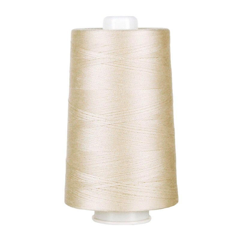 Large spool of cream thread on a white background