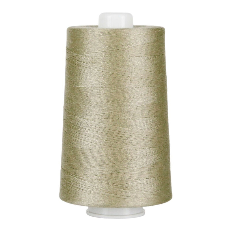 Large spool of taupe thread on a white background