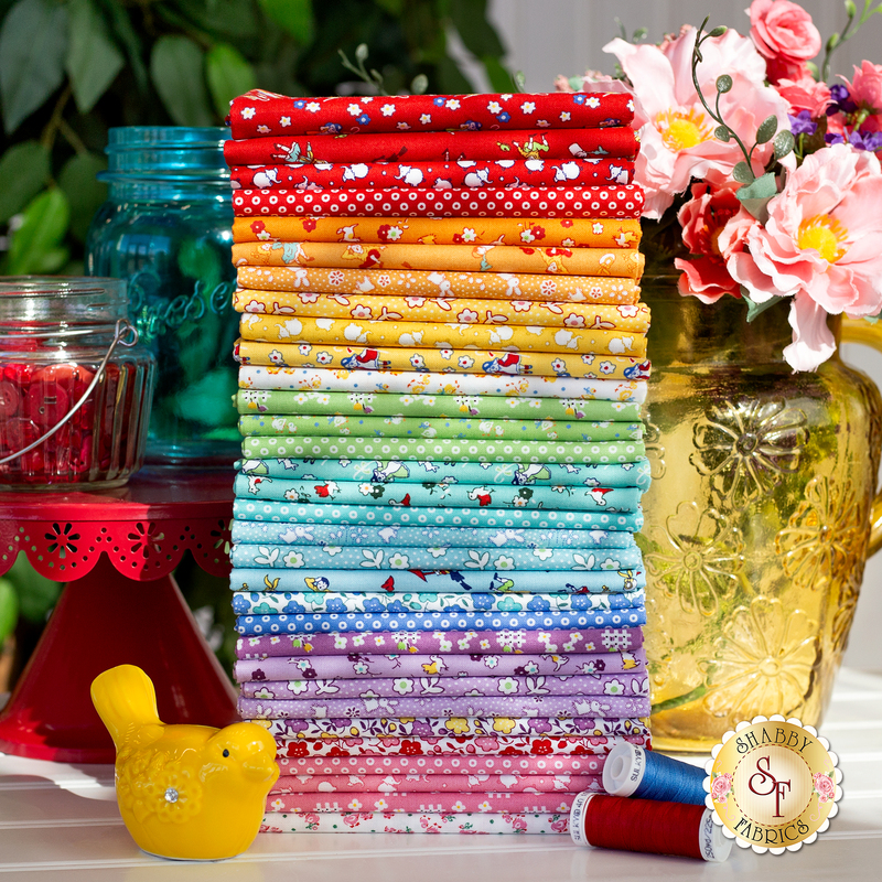 Storytime 30s collection stacked beautifully and staged beside props in primary colored jars, thread, and a little yellow bird, with sunshine gently streaming onto the fabric. 