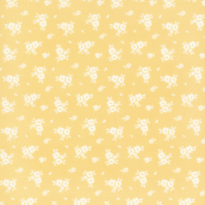 Swatch of light yellow fabric with scattered white flower silhouettes 