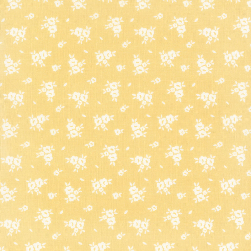 Swatch of light yellow fabric with scattered white flower silhouettes 