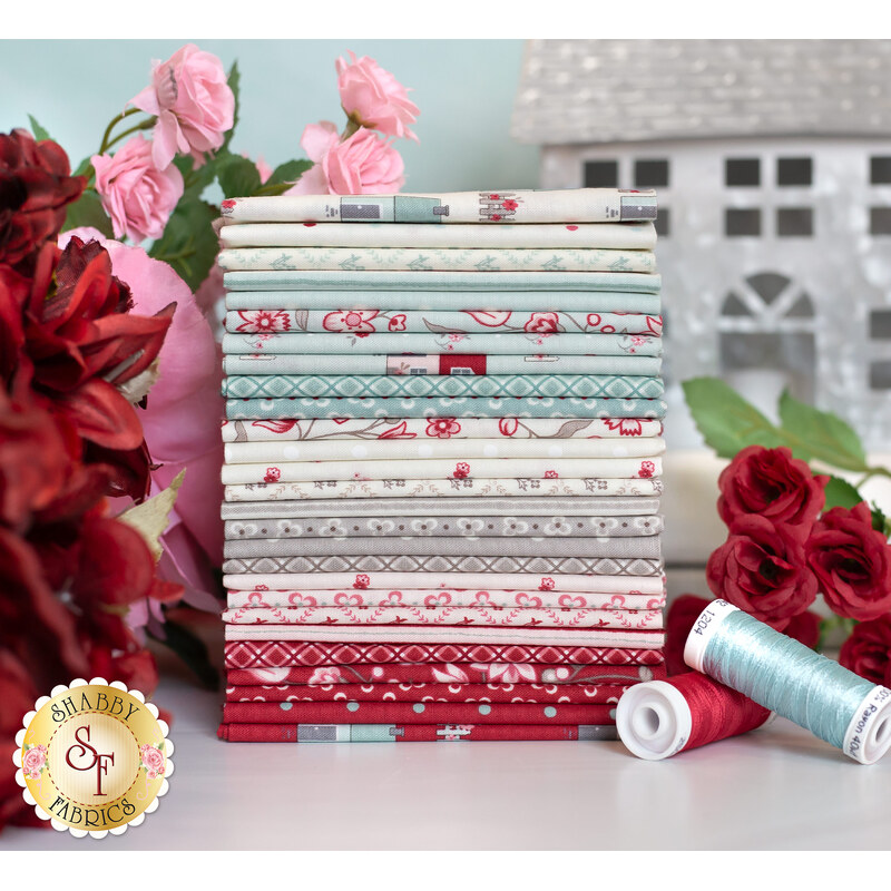 photo of my summer house fabric bundle in front of a tin house and surrounded by pink and red flowers.