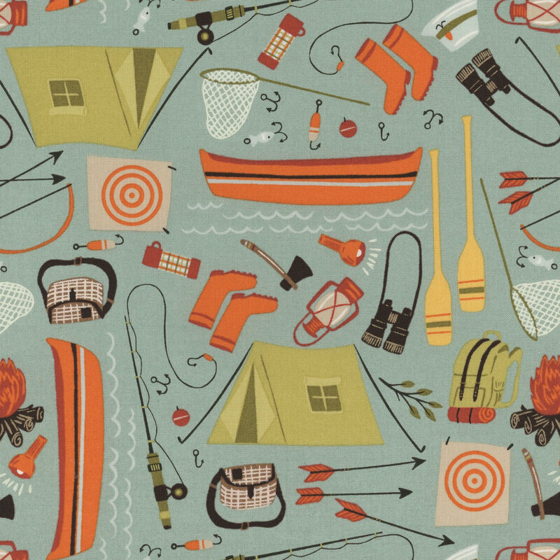 Dusty blue fabric covered in orange, beige and green camping, hunting, and fishing motifs like tents, backpacks, fishing poles, arrows, a canoe, and more.