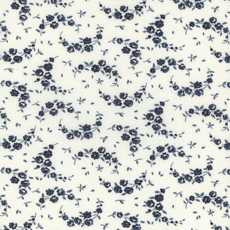 light cream fabric with scattered navy blue leaves and flowering crescent shaped vines