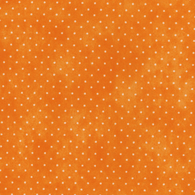 Mottled orange fabric with small white polka dots.