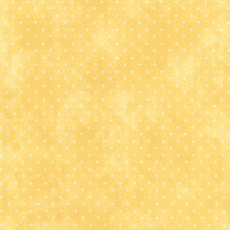 Mottled yellow fabric with small white polka dots.