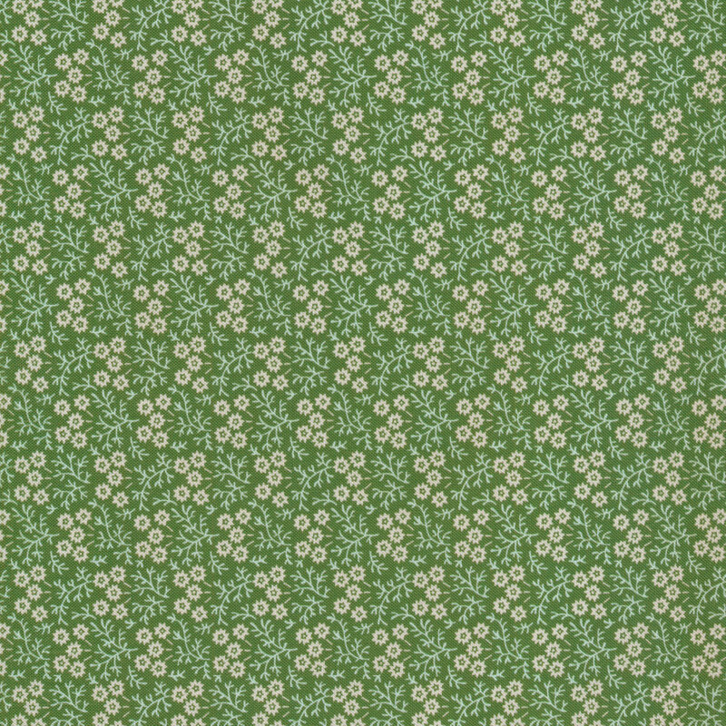Floral print with small cream flowers against a green fabric.