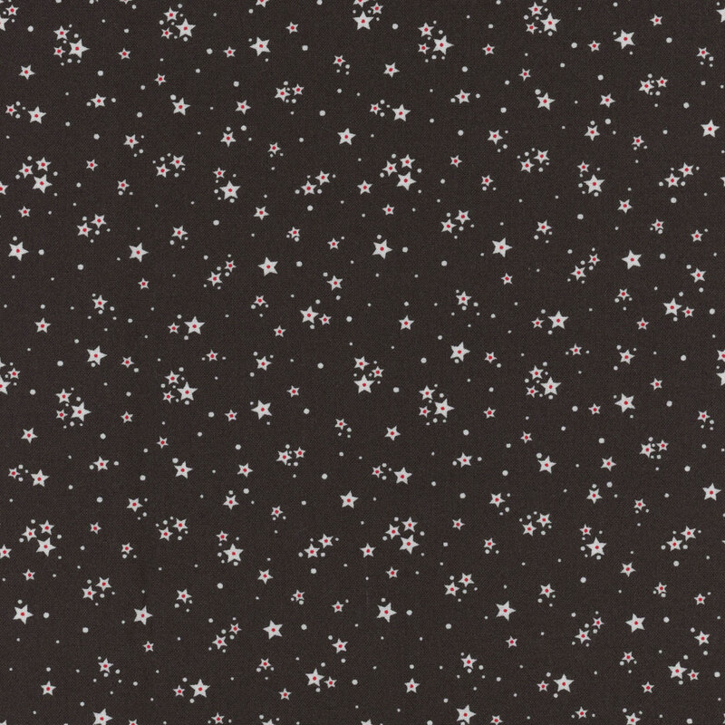Black fabric with clusters of white stars with a tiny red accent and tiny dots scattered in the background