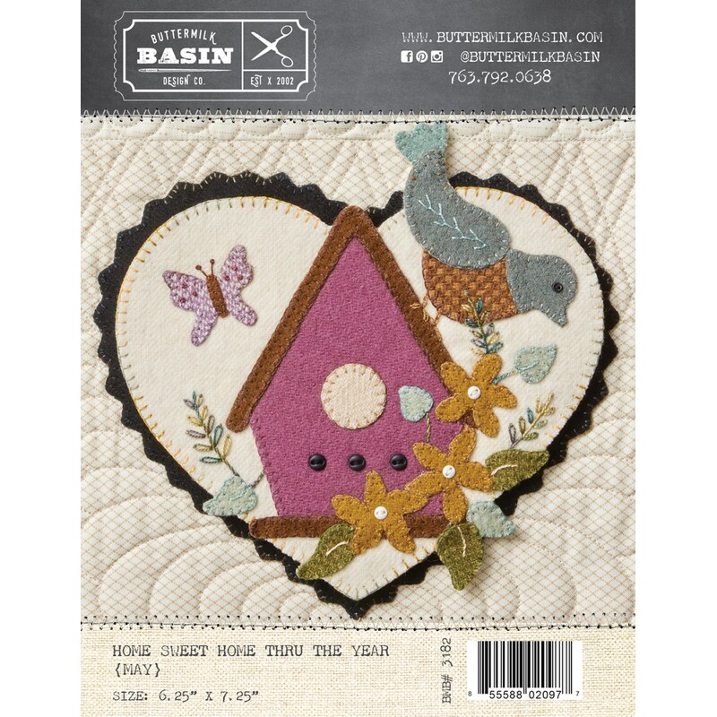 Front of pattern with finished heart featuring a woolen bird perched on a pink birdhouse, surrounded by flowers and a butterfly