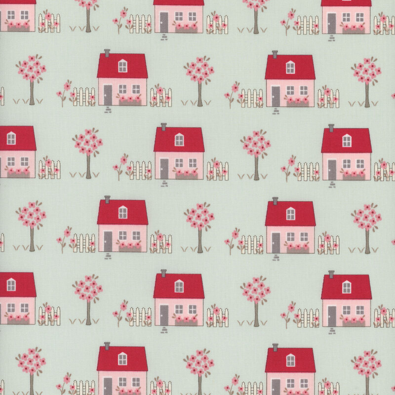fabric with houses and trees in shades of red and pink on light blue background