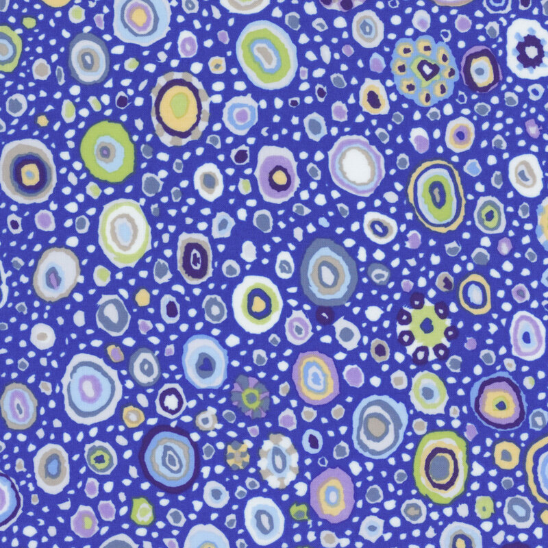Fabric featuring vibrant white, green, black, and golden yellow abstract dots and mosaics over a royal blue background