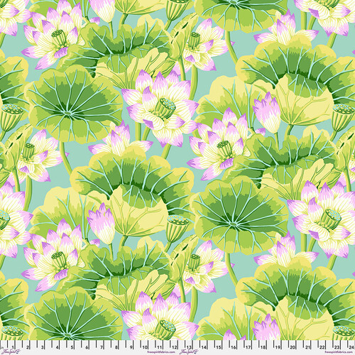 Fabric featuring vibrant pink, white, and yellow lotus blossoms and vivid green leaves over a dusty blue background