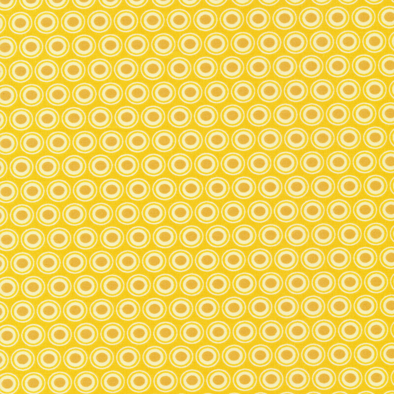 golden yellow fabric with a lovely cream and dark gold oval polka dot design