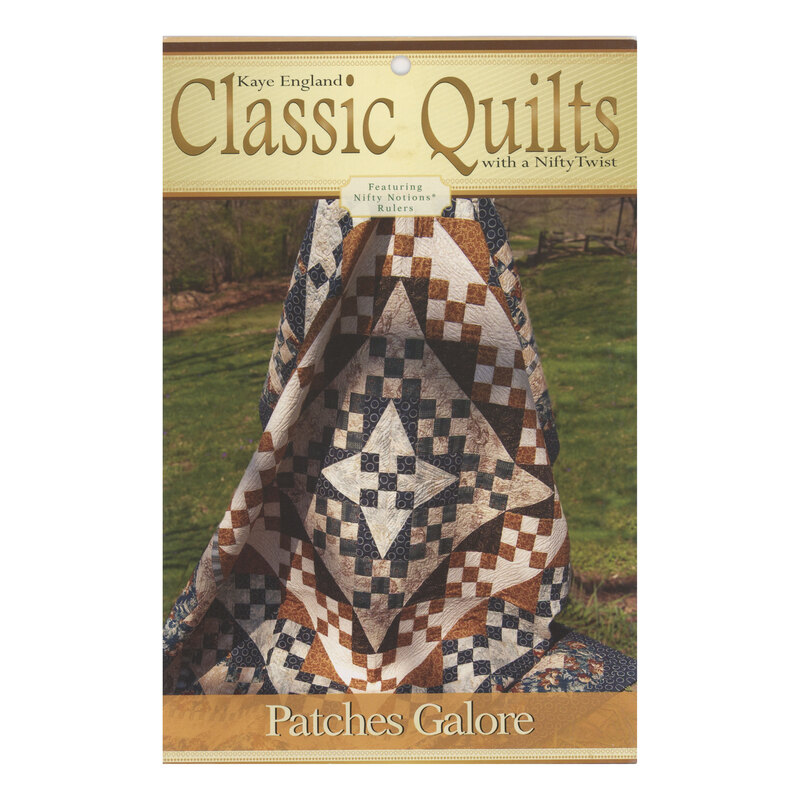 Front of pattern packet featuring the completed quilt, held aloft and draped outside