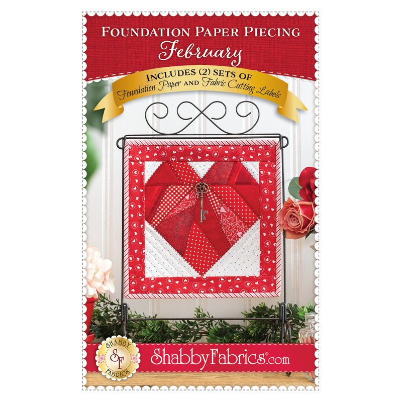 Front cover of the pattern booklet showing the finished project of a pieced heart with key charm, title of pattern, and designer info