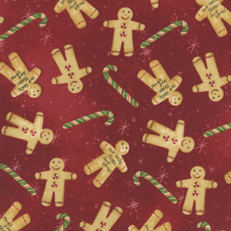 snowflake covered dark red fabric adorned with scattered green candy canes and gingerbread cookies