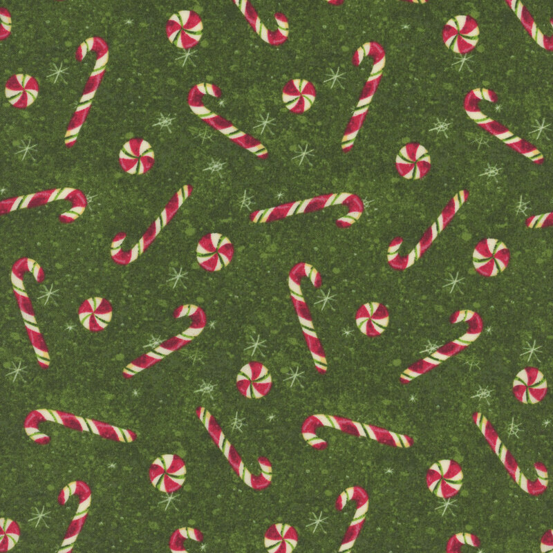 snowflake covered forest green fabric adorned with scattered red candy canes and peppermint swirl candies
