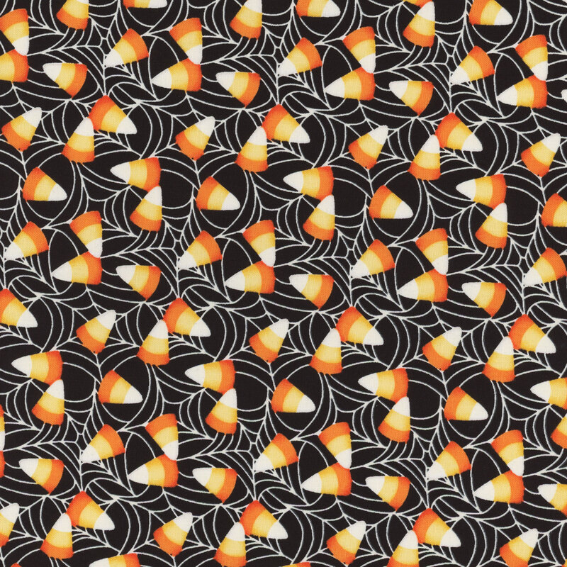 delightful black fabric with scattered candy corn over a spiderweb