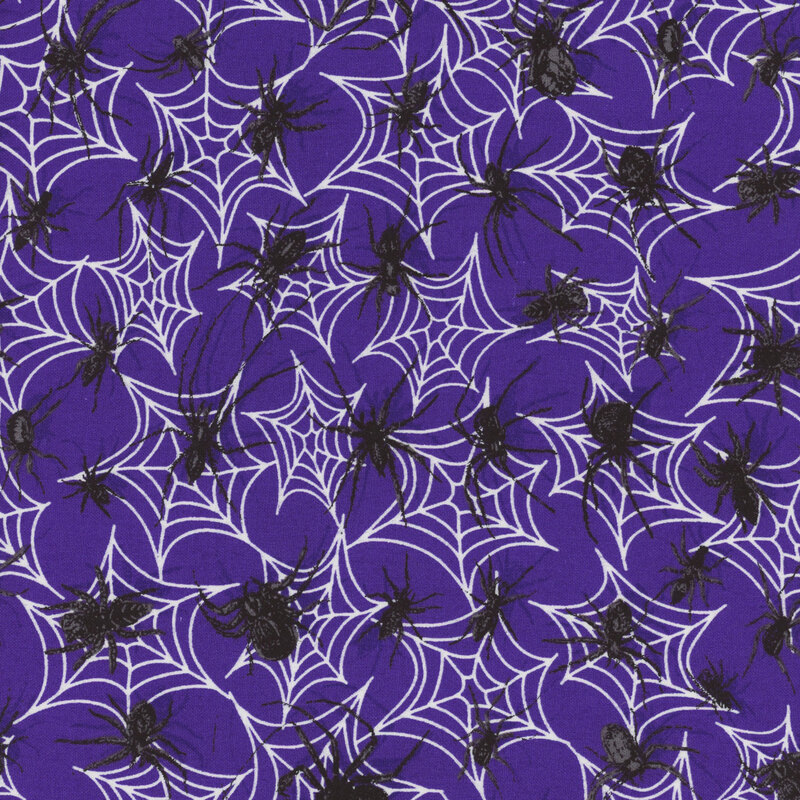 delightful indigo fabric with scattered spiderwebs and crawling black spiders