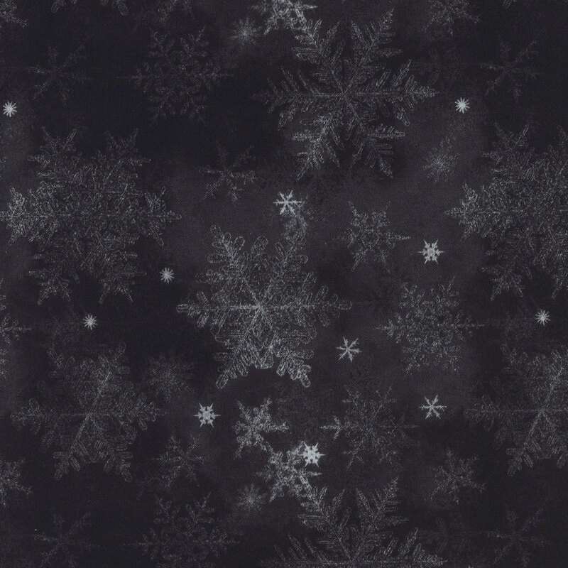 mottled black fabric featuring scattered gray and white snowflakes
