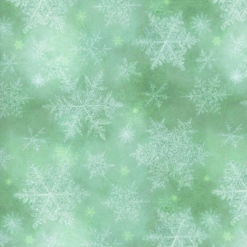 green mottled fabric featuring scattered white and mint snowflakes