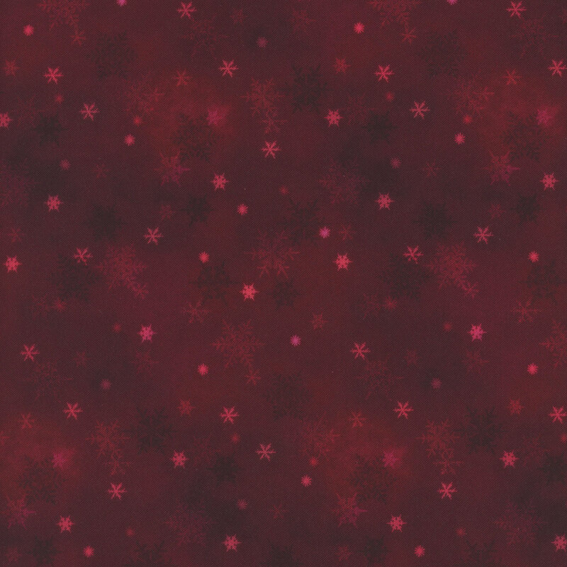dark red mottled fabric featuring small scattered tonal snowflakes