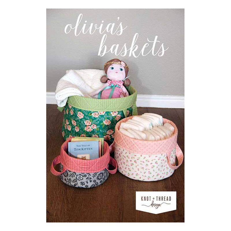 Front of the pattern showing three finished sizes of the truly adorable baskets in action, holding baby books, diapers, and a blanket and doll.
