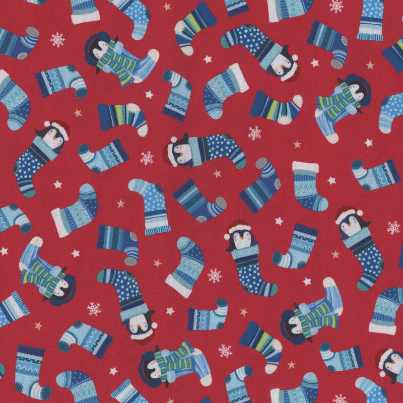 Red fabric with penguins in various shades of blue Christmas stockings.