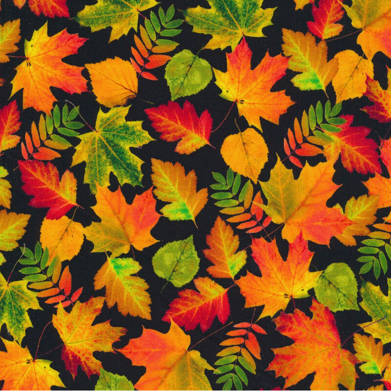 fabric with leaves in shades of red, orange, and green on a black background