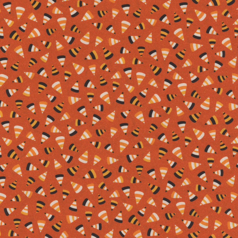 speckled orange fabric with various scattered candy corn