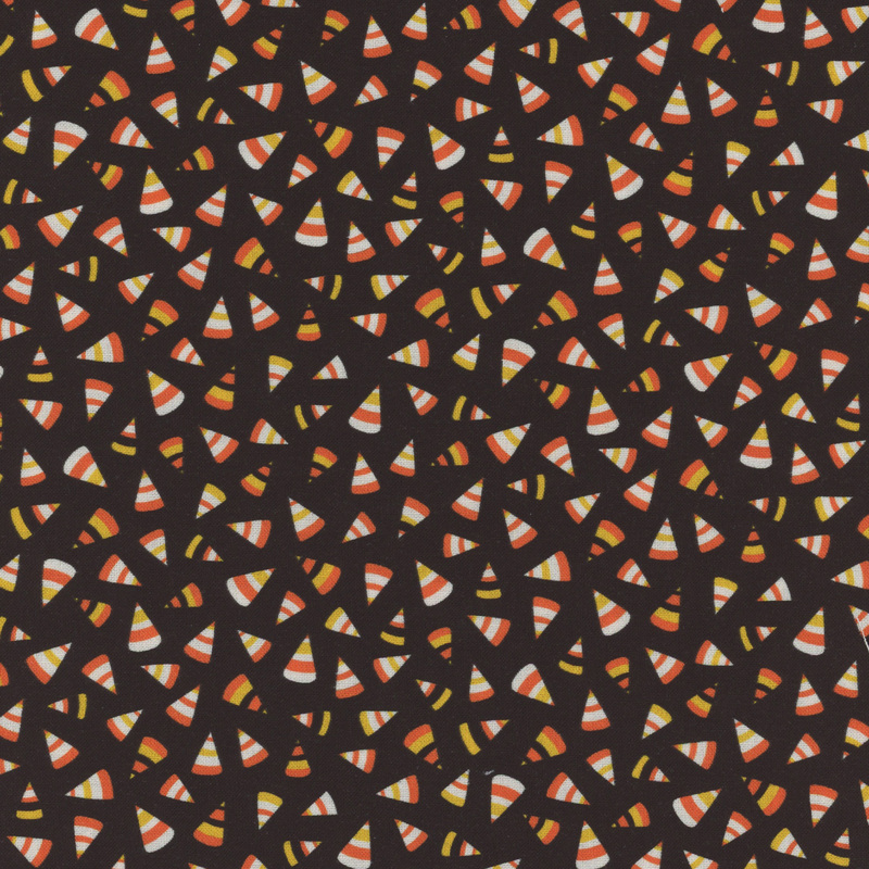 speckled black fabric with various scattered candy corn