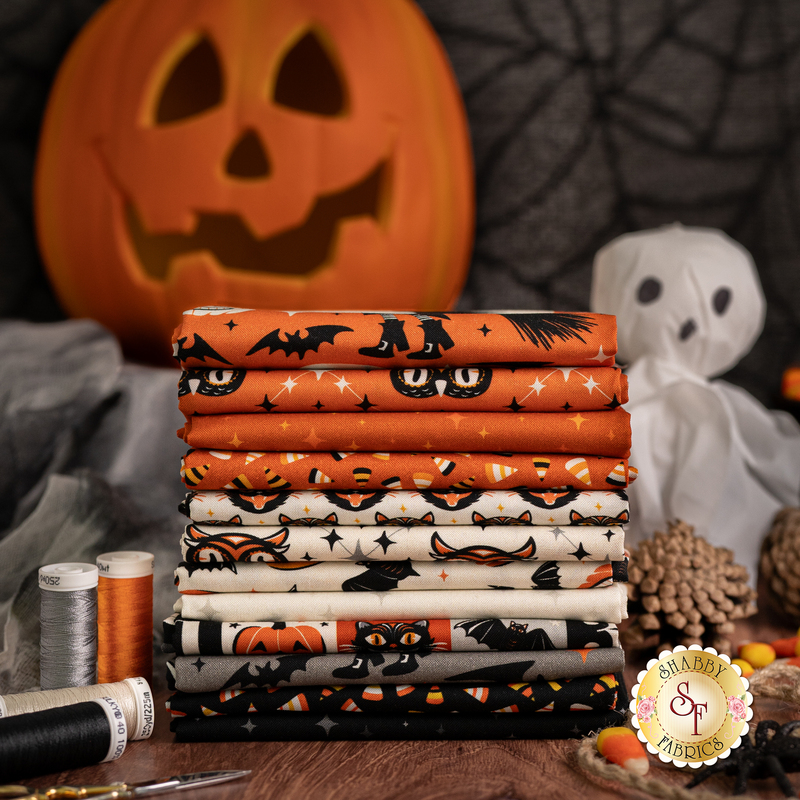 photography of the witching hour fabrics layered over each other, from black to orange to cream surrounded by halloween decor