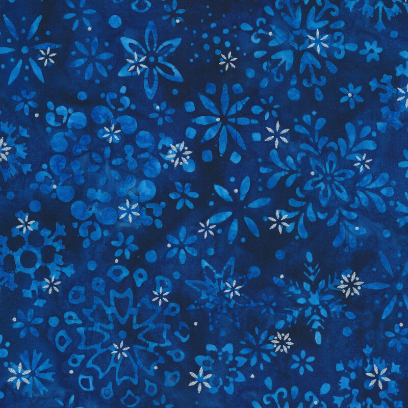 dark blue mottled fabric featuring various scattered snowflakes and accented with metallic silver snowflakes