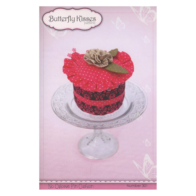 Front cover of pattern, showing the completed pincushion staged on a pedestal cake plate for effect