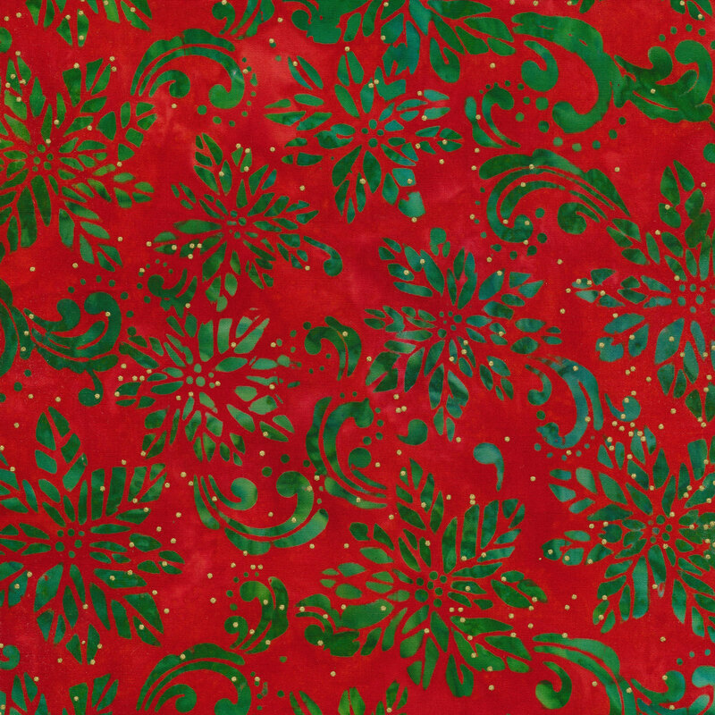 Red mottled batik fabric with a green poinsettia design and swirls with gold metallic dots.