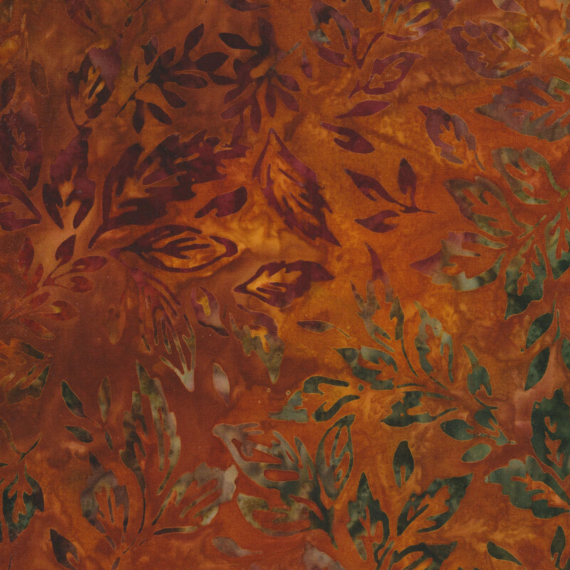 burnt orange mottled fabric featuring scattered leaves in shades of mottled green and maroon