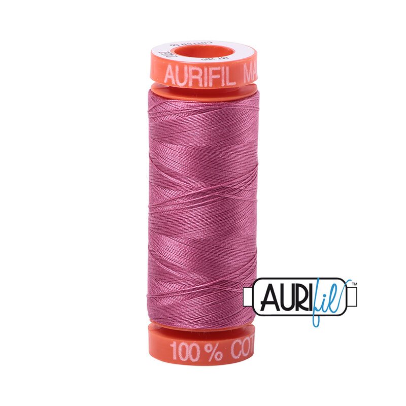 Dusty Rose thread on an orange spool, isolated on a white background