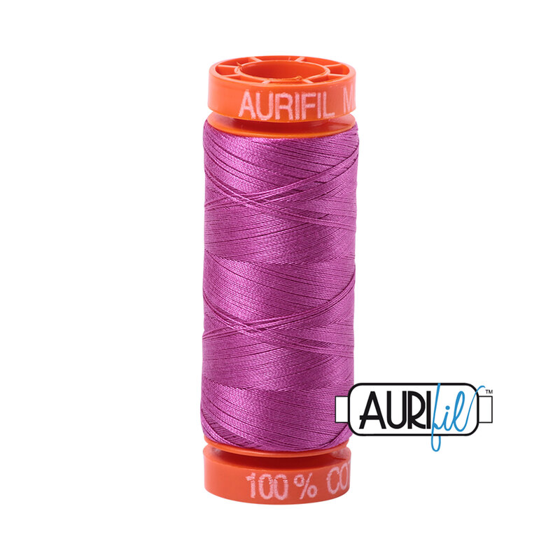 Magenta thread on an orange spool, isolated on a white background