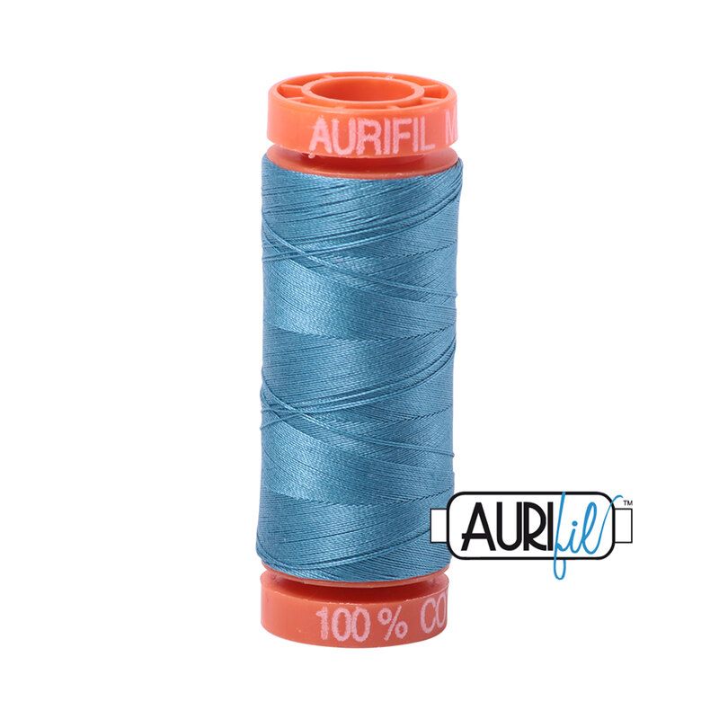 Teal thread on an orange spool, isolated on a white background