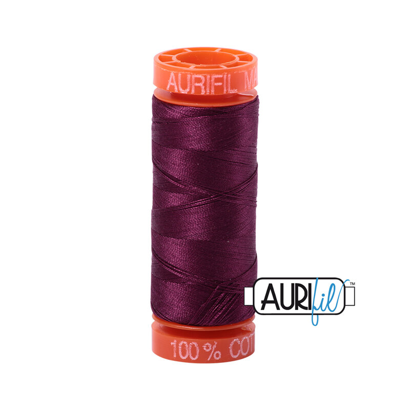 Plum thread on an orange spool, isolated on a white background