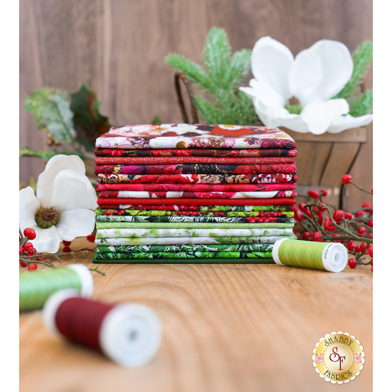 A stack of the fabric collection Hand Picked: Christmas surrounded by festive decor.