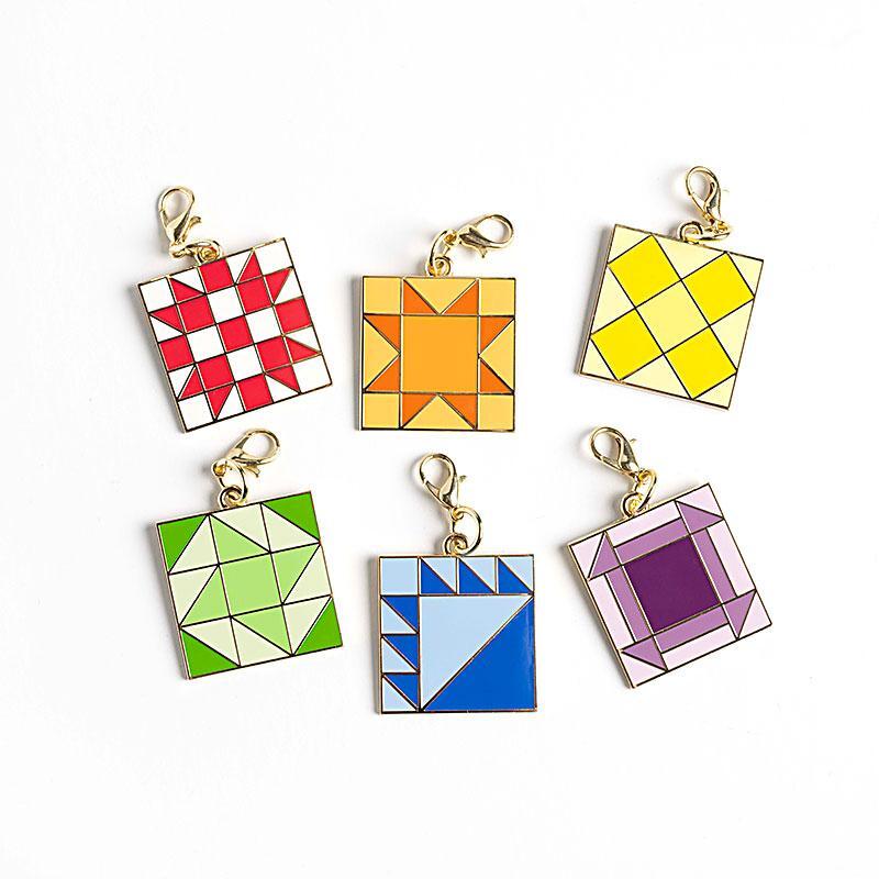 6 classic quilt block themed enamel charms isolated on a white background