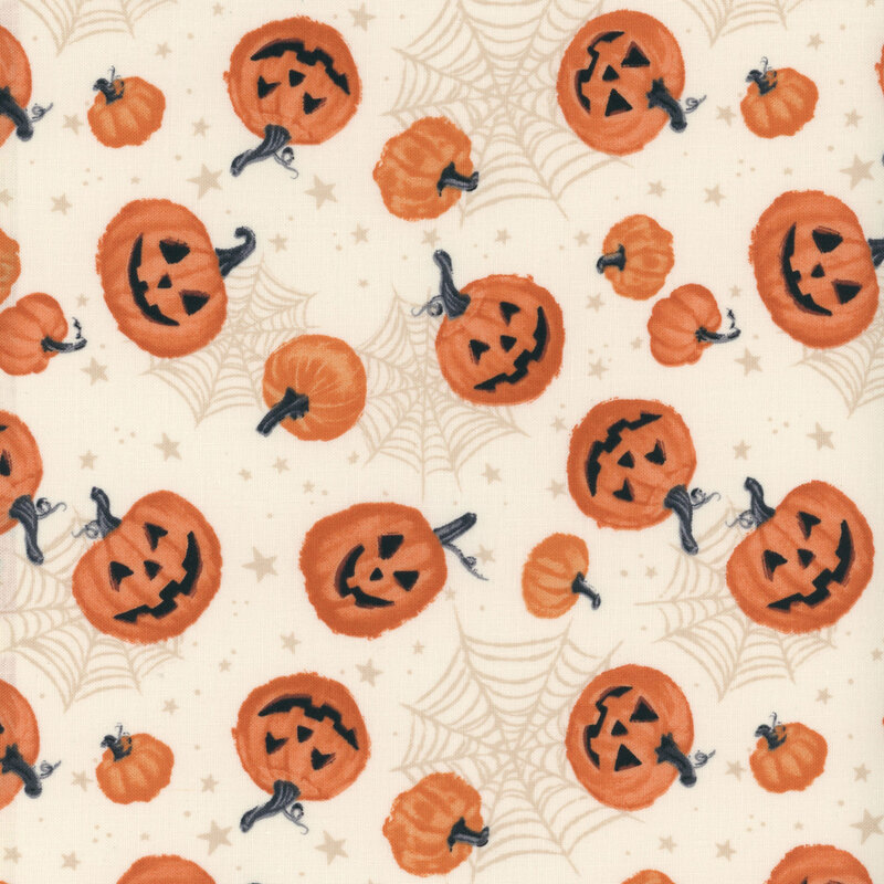 fabric featuring pumpkins and jack o'lanterns on a cream background with spiderwebs and stars in the background